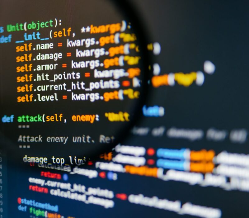 program-code-on-computer-display-in-magnifying-gla-2024-12-05-07-12-20-utc